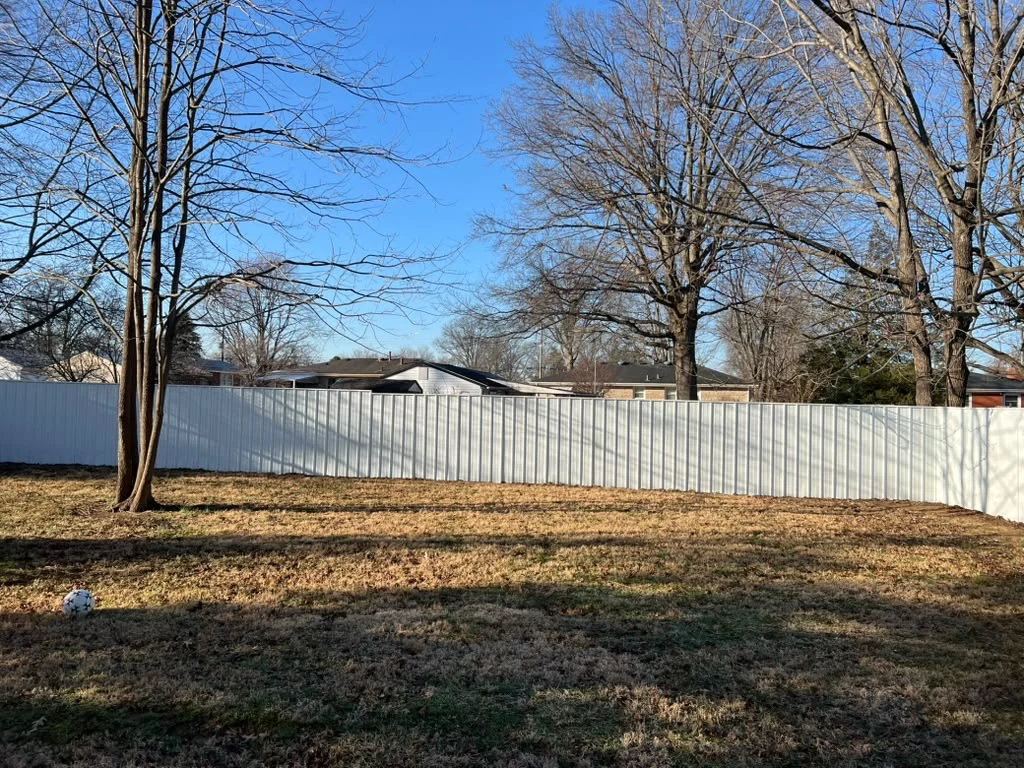 White privacy fence along a spacious yard